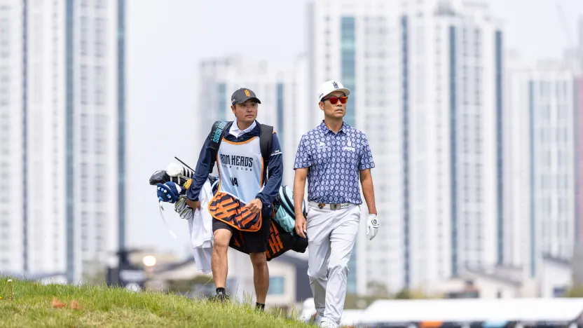 Captain Kevin Na of Iron Heads GC and caddie, Kurt Kowaluk, on the first hole during the first round of LIV Golf Korea at Jack Nicklaus Golf Club on Friday, May 02, 2025 in Incheon, South Korea. (Photo by Chris Trotman/LIV Golf)