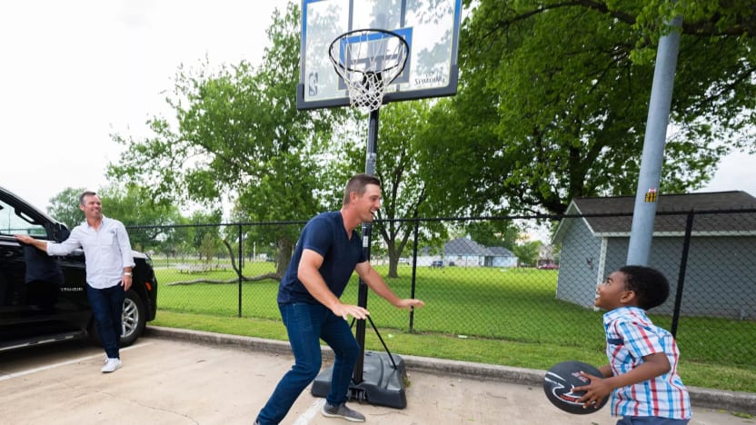 Captain Bryson DeChambeau of Crushers GC and Charles Howell III of Crushers GC play basketball with an attendee ahead of LIV Golf Tulsa at the Lindsey House on Wednesday, May. 10, 2023 in Tulsa, Oklahoma. (Photo by Charles Laberge/LIV Golf)
