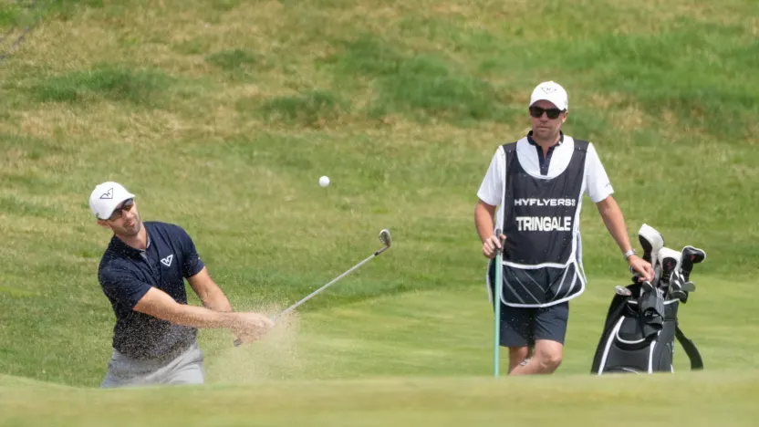 Caddie, Jonathan Smart, watches as Cameron Tringale of HyFlyers GC hits his shot from a bunker on the 15th hole during the first round of LIV Golf Korea at Jack Nicklaus Golf Club on Friday, May 02, 2025 in Incheon, South Korea. (Photo by Mike Stobe/LIV Golf)