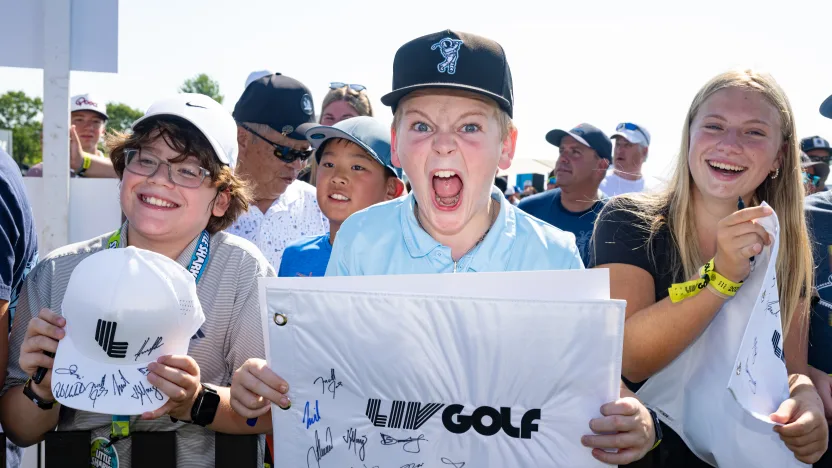 Young fans hold flags and hats as they wait for autographs before the first round of LIV Golf Chicago at Bolingbrook Golf Club on Friday, August 08, 2025 in Bolingbrook, Illinois. (Photo by Charles Laberge/LIV Golf)