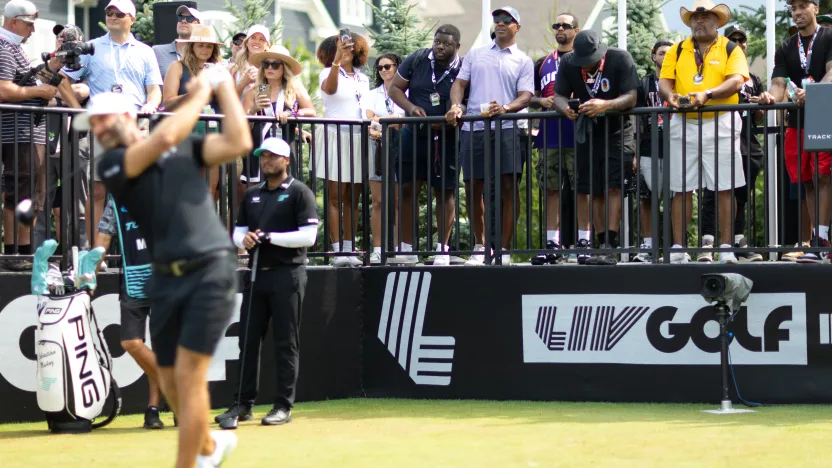 Former NBA point gaurd and current ESPN analyst, Jay Williams and American Jornalist, Roland Martin watches as Captain Dustin Johnson of 4Aces GC hits his shot from the first tee during the second round of LIV Golf Indianapolis at The Club at Chatham Hills on Saturday, August 16, 2025 in Westfield, Indiana. (Photo by Jon Ferrey/LIV Golf)