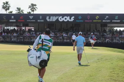 Dean Burmester of Stinger GC walks with his caddie on the 18th hole in front of Club 54 during the second round of LIV Golf Orlando at Orange County National on Saturday, Apr. 01, 2023 in Winter Garden, Florida. (Photo by Jon Ferrey/LIV Golf)